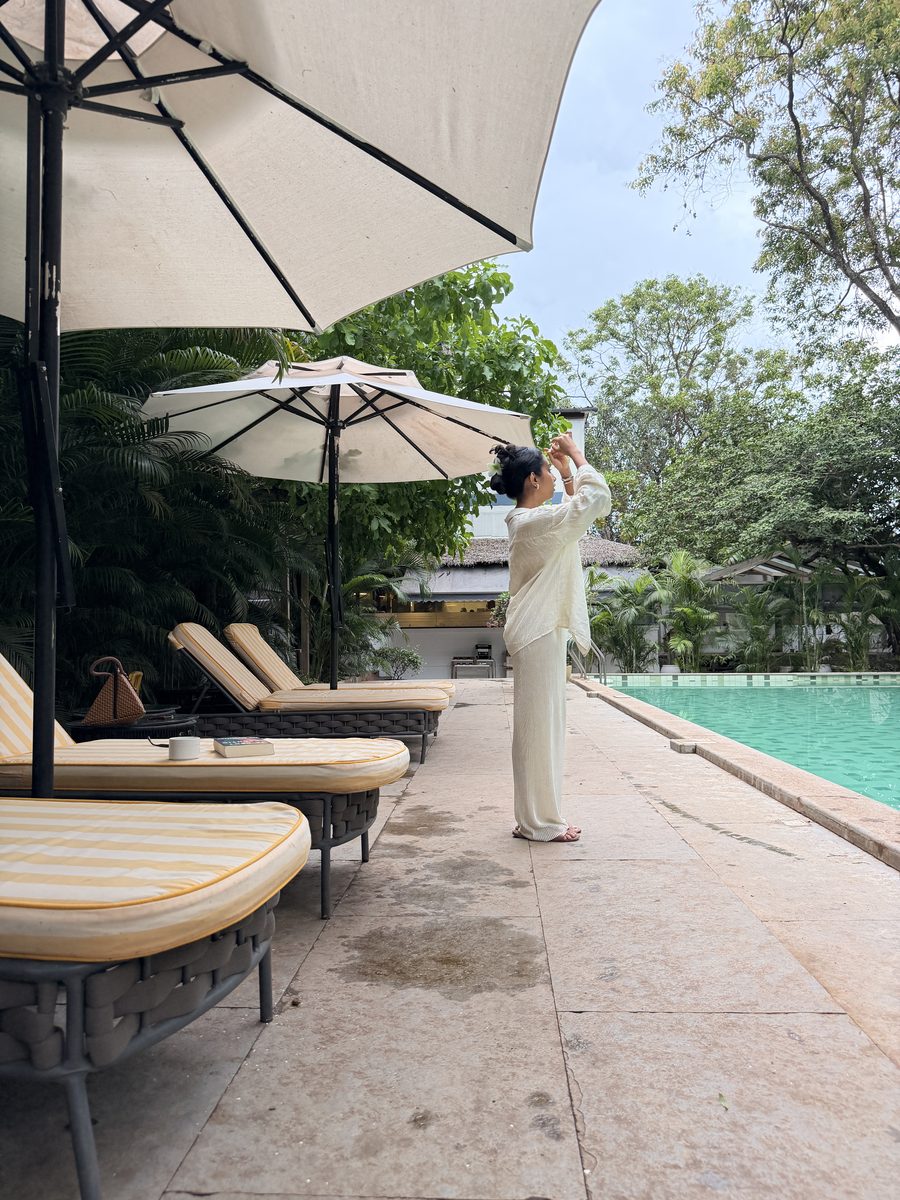 Reva by a resort pool under parasols