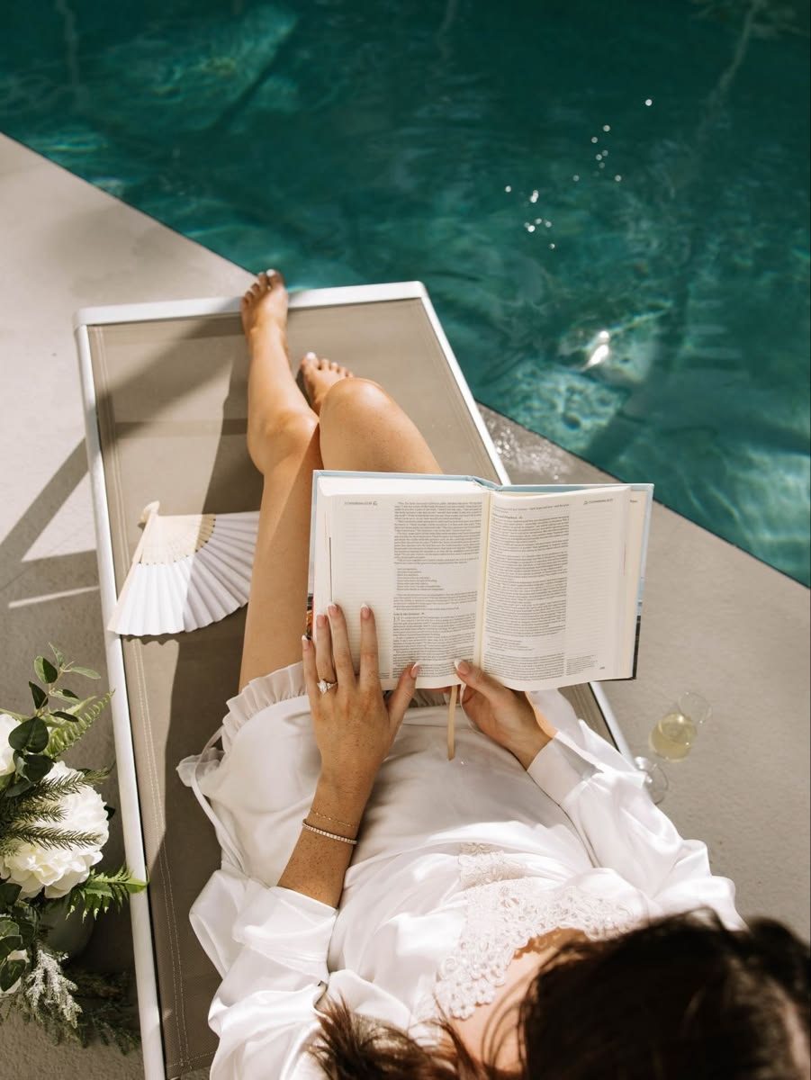 Creator reading beside a quiet pool